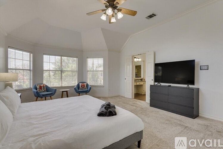 A bedroom with a large bed and a flat screen TV.