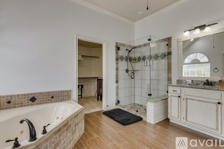 A bathroom with a tub, sink, and mirror.