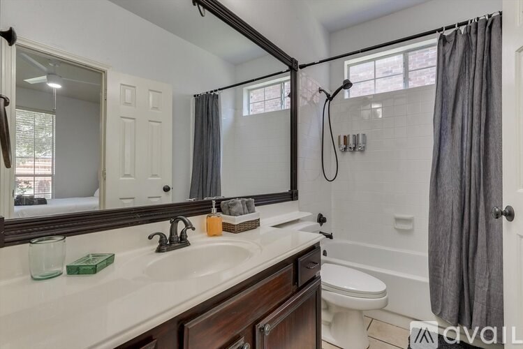A bathroom with a white sink and a mirror above it.