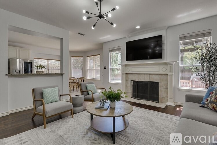 A living room with a fireplace and a television mounted on the wall.