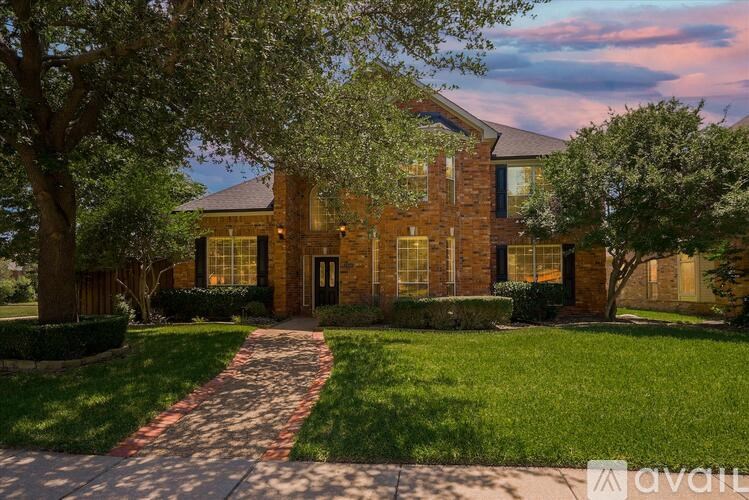 A house with a brick facade and a red pathway leading to the front door.