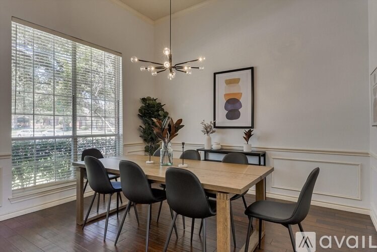 A dining room with a table and chairs.