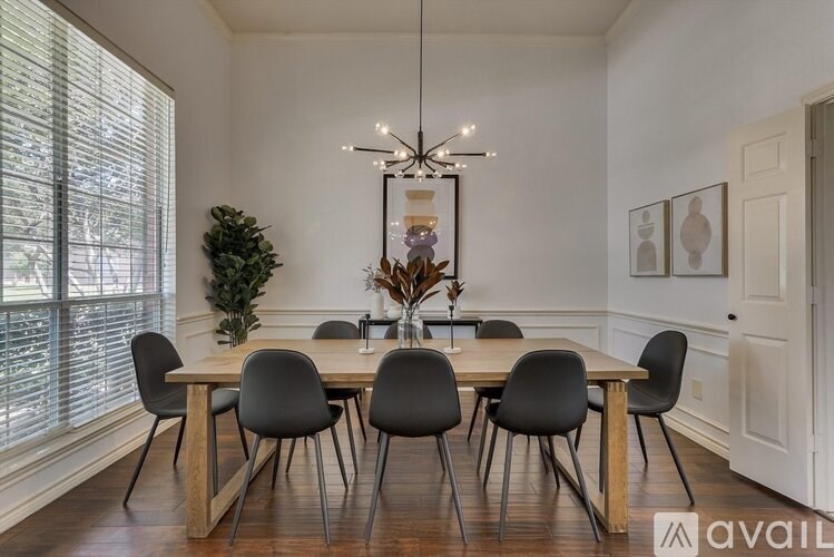 A dining room with a wooden table and chairs.