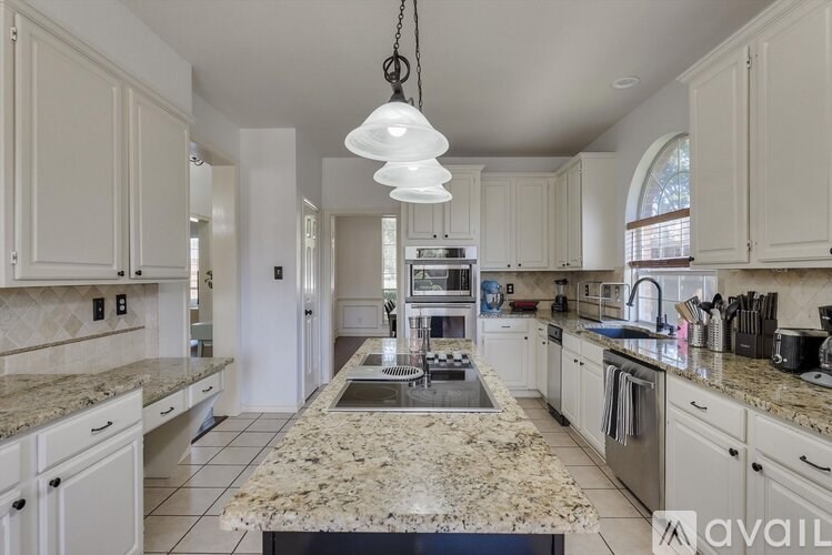 A kitchen with granite countertops and white cabinets.