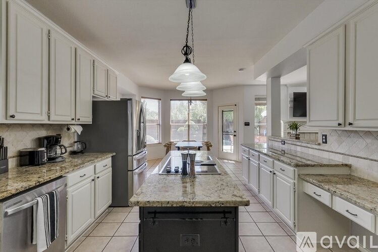 A kitchen with white cabinets and a granite countertop.