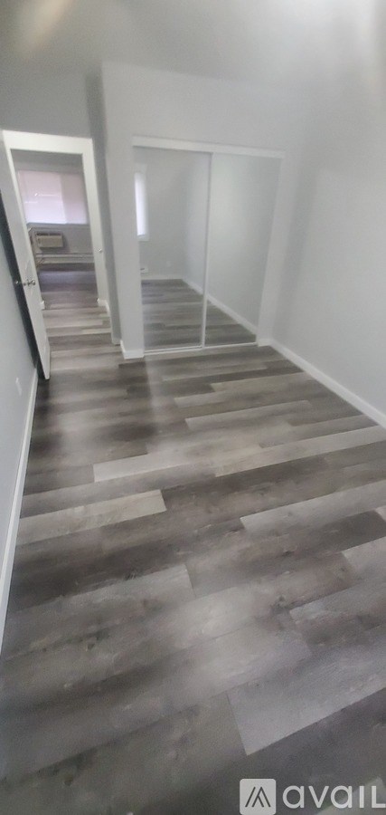 A room with wooden flooring and white walls.