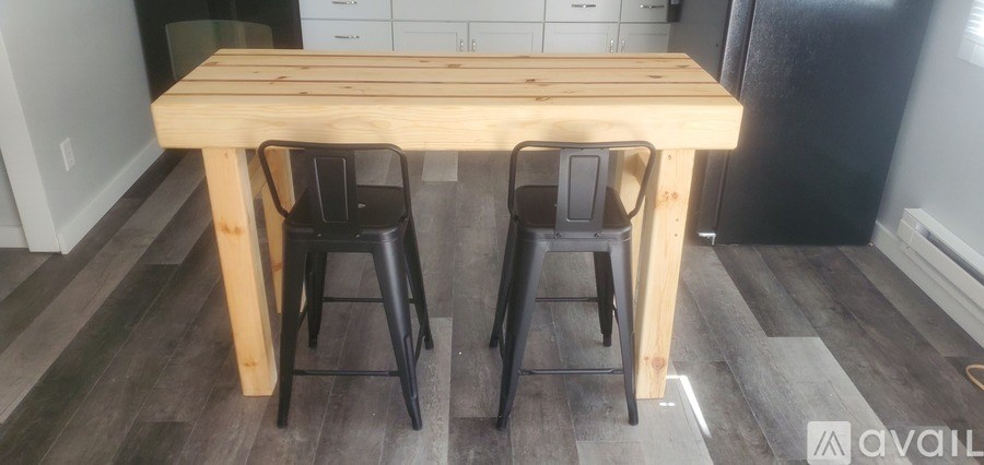 A wooden table with two stools in a kitchen.