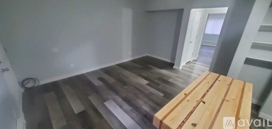 A room with wooden flooring and a wooden table.