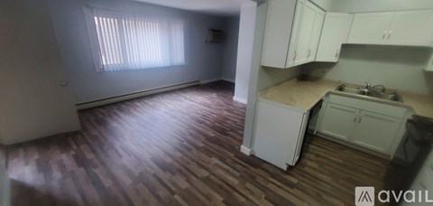 A kitchen with white cabinets and a checkered floor.