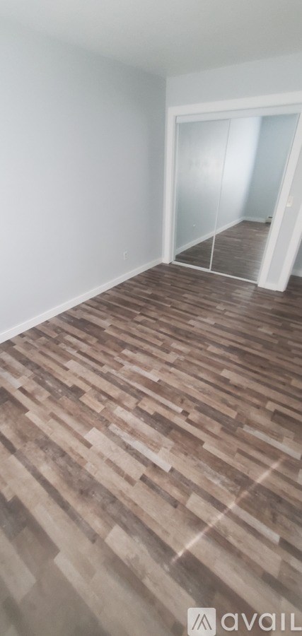 A room with wooden flooring and white walls.