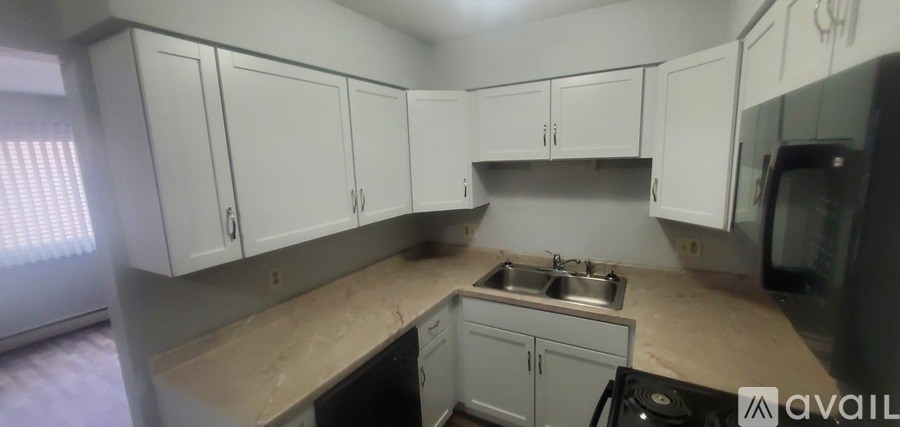 A kitchen with white cabinets and a sink.