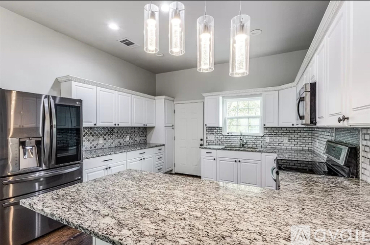 A kitchen with granite countertops and stainless steel appliances.
