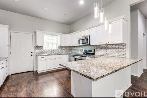 A kitchen with white cabinets and a granite countertop.