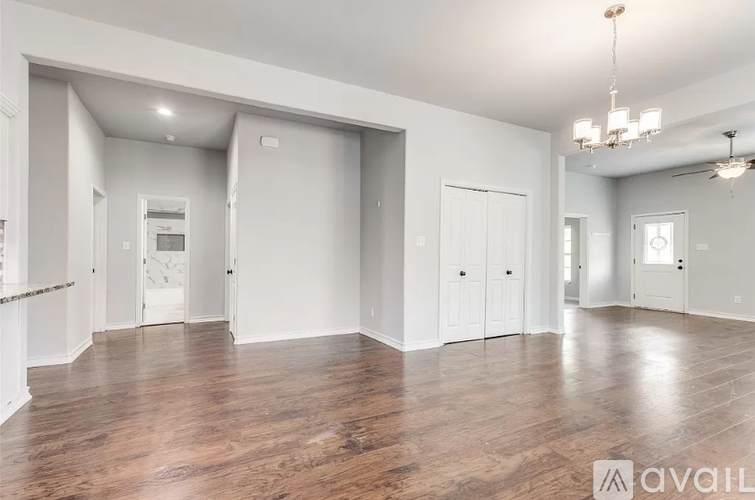 A spacious room with wooden floors and white walls.