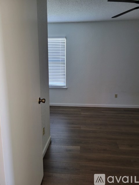 A room with wooden floors and a ceiling fan.