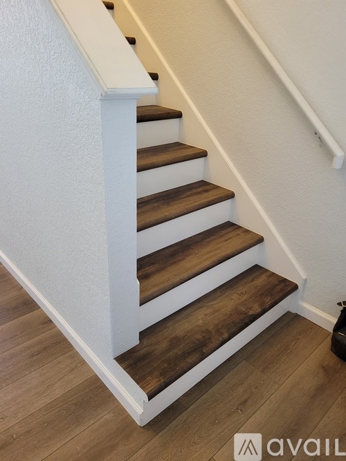 A set of stairs with white risers and wooden treads.