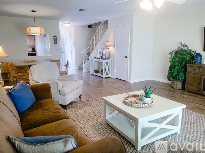 A living room with a white coffee table and brown couch.