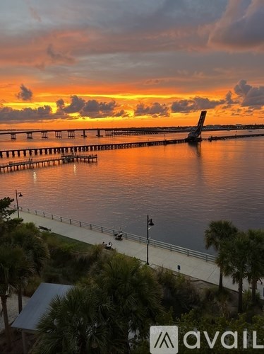 A sunset view with a dock and a plane in the water.