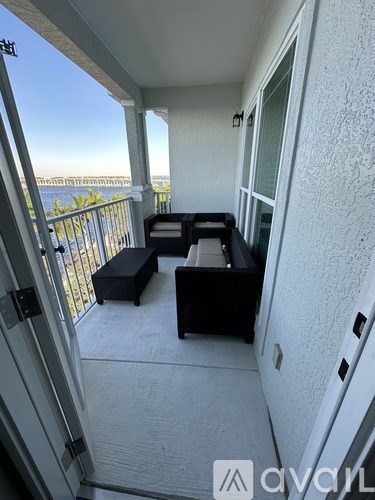 A balcony with a table and chairs overlooking the ocean.