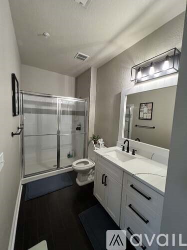 A bathroom with a toilet, sink, and mirror.