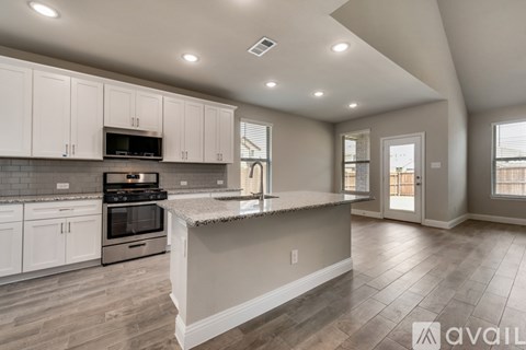 A kitchen with white cabinets and a central island.