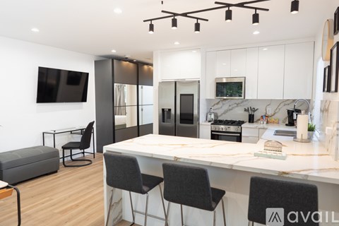 A modern kitchen with a bar area and a television.