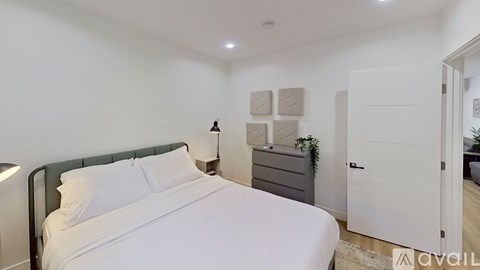 A bedroom with a bed, nightstand, and lamp.