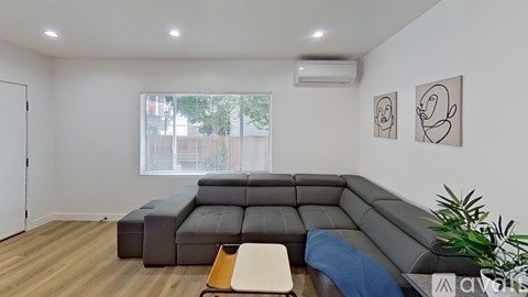 A living room with a grey sofa and two abstract art pieces on the wall.
