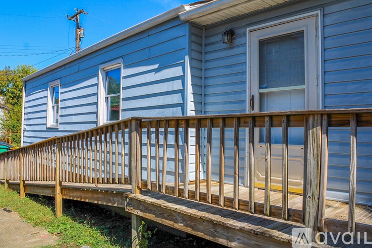 A blue house with a wooden deck in front.