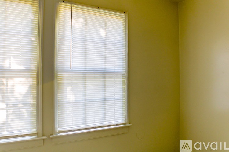 A window with white blinds in a room.