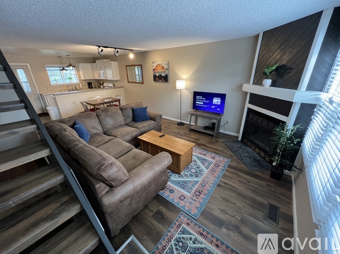 A living room with a couch, a coffee table, and a TV.