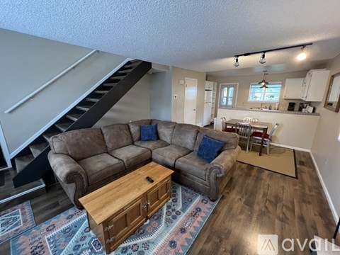 A living room with a brown couch and a wooden coffee table.