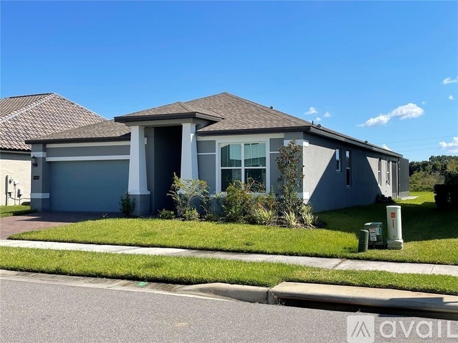 A house with a grey roof and a white garage door.