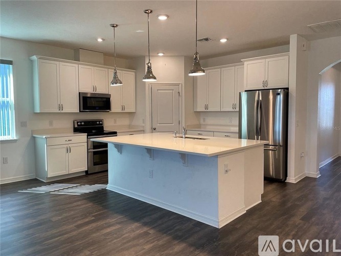 A kitchen with white cabinets and a large island.