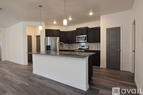 A kitchen with a white island and dark wood cabinets.