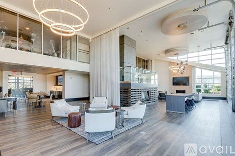 A spacious living room with a white sofa set and a large window.