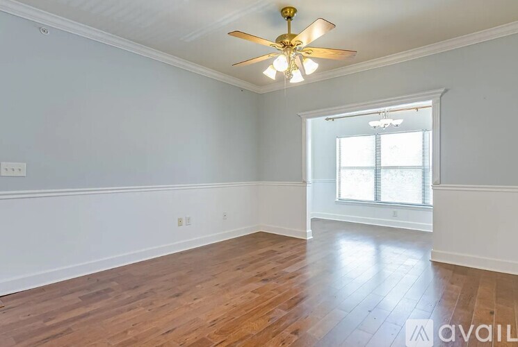A room with a ceiling fan and a window.