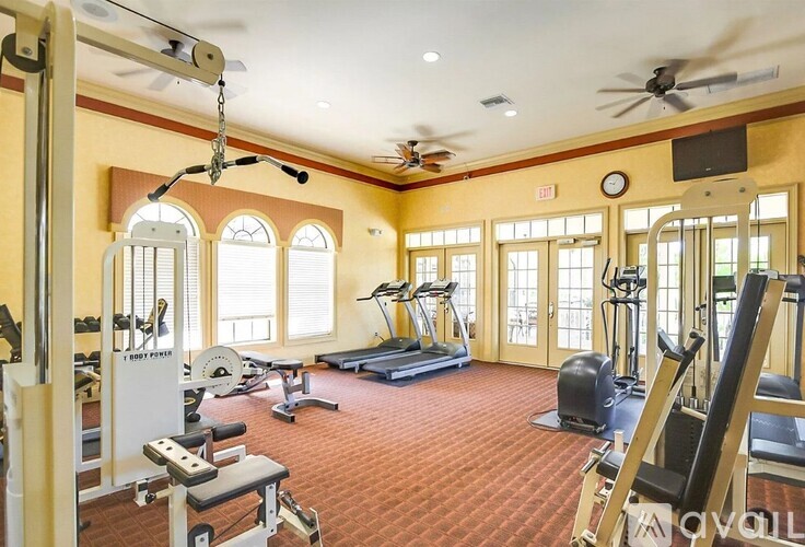 A gym with a variety of equipment including treadmills, weights, and exercise machines.