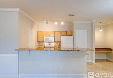 A kitchen with white cabinets and a granite countertop is available.