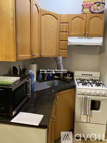 A kitchen with wooden cabinets and a white stove.