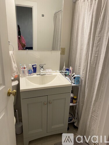 A bathroom with a sink, mirror, and toiletries.