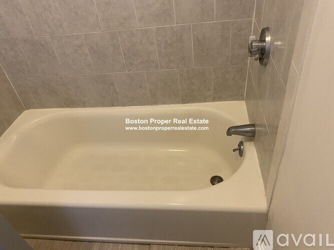 A white bathtub in a bathroom with a silver faucet.