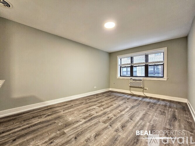 A spacious room with wooden flooring and a white ceiling.