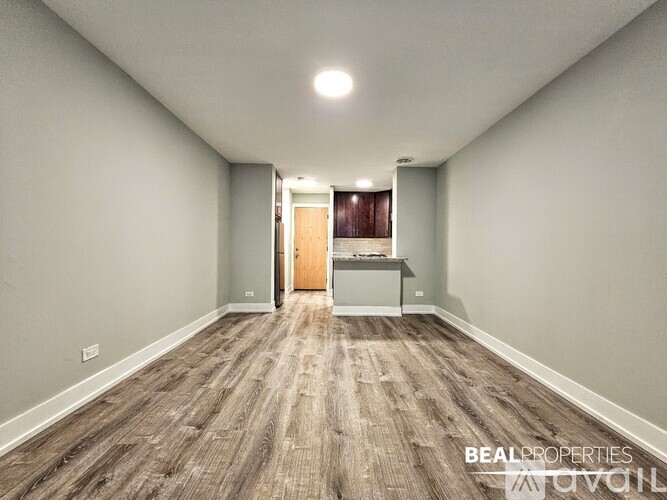A kitchen with brown cabinets and a black fridge.