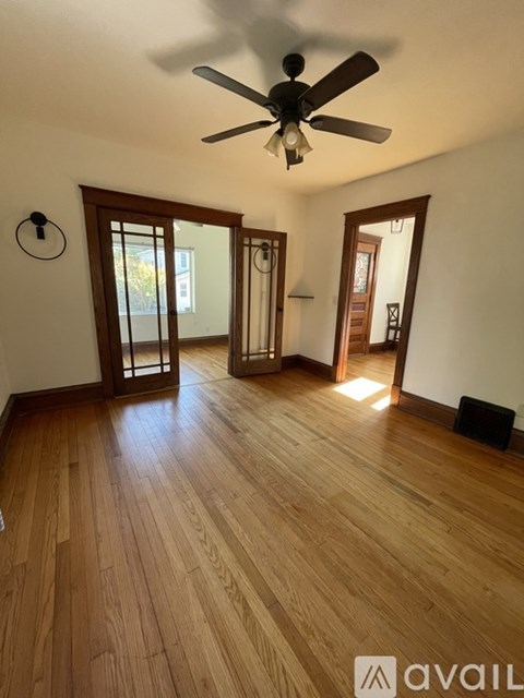 A room with wooden floors and a ceiling fan.