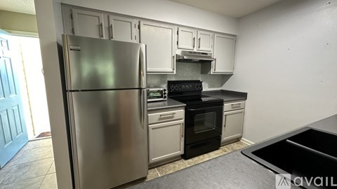 A kitchen with a stainless steel refrigerator and black oven.