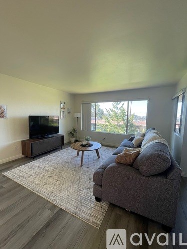 A living room with a grey couch and a television.
