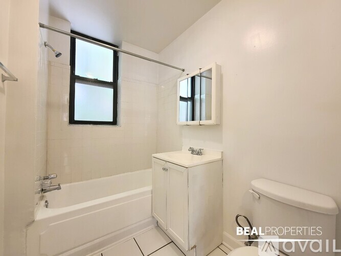 A spacious room with wooden flooring and a ceiling fan.