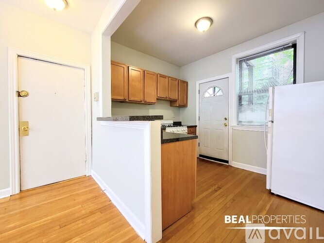 A kitchen with wooden cabinets and a white fridge is shown in the image.