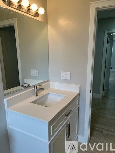 A bathroom with a sink and mirror.